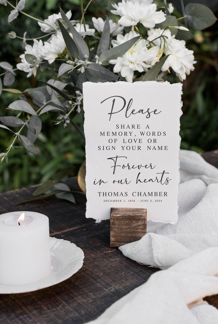 a sign that says please on it next to a candle and some flowers in the background