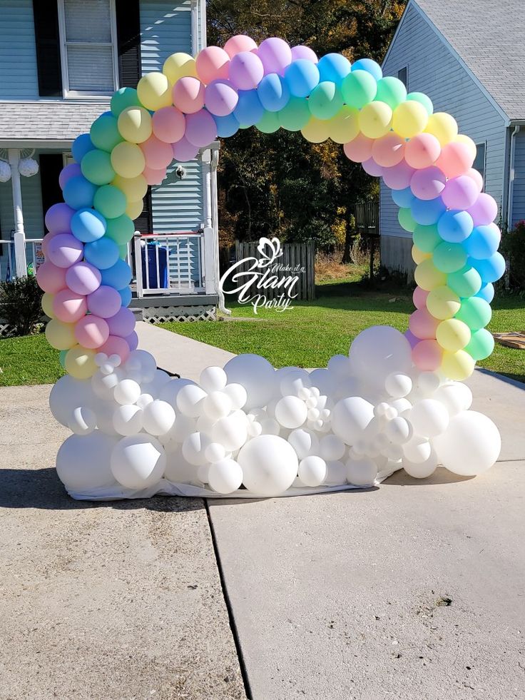 an arch made out of balloons in front of a house