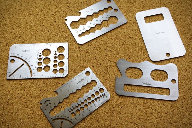 four different types of metal parts laying on the ground together, all with holes in them