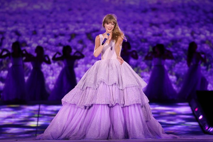 a woman in a purple dress on stage