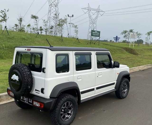 the white jeep is parked on the side of the road