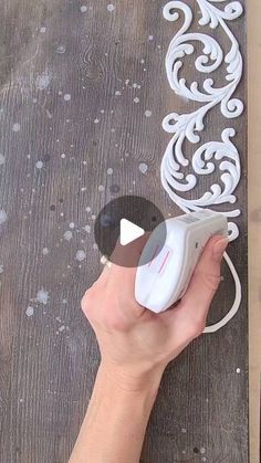 a person is using a mouse to cut out the design on a piece of wood