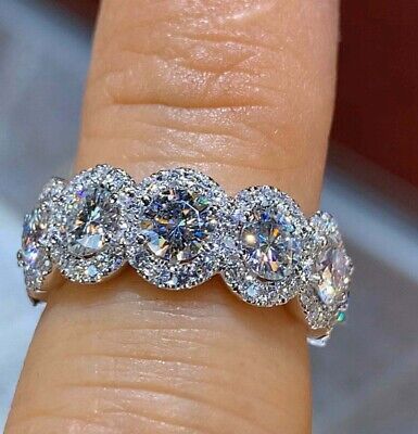 three stone diamond ring sitting on top of someone's finger in front of the camera