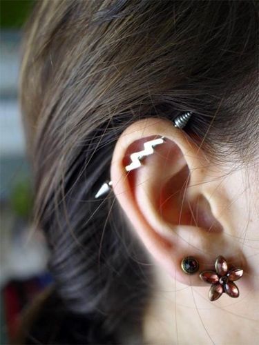 a woman with two piercings on her ear and one has an arrow in the middle