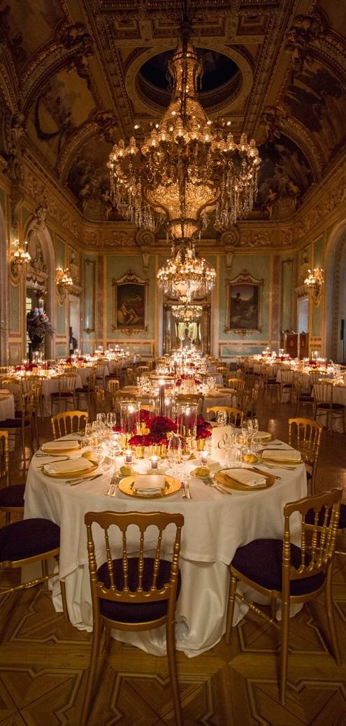 a fancy dining room with chandeliers and tables set for dinner or other function