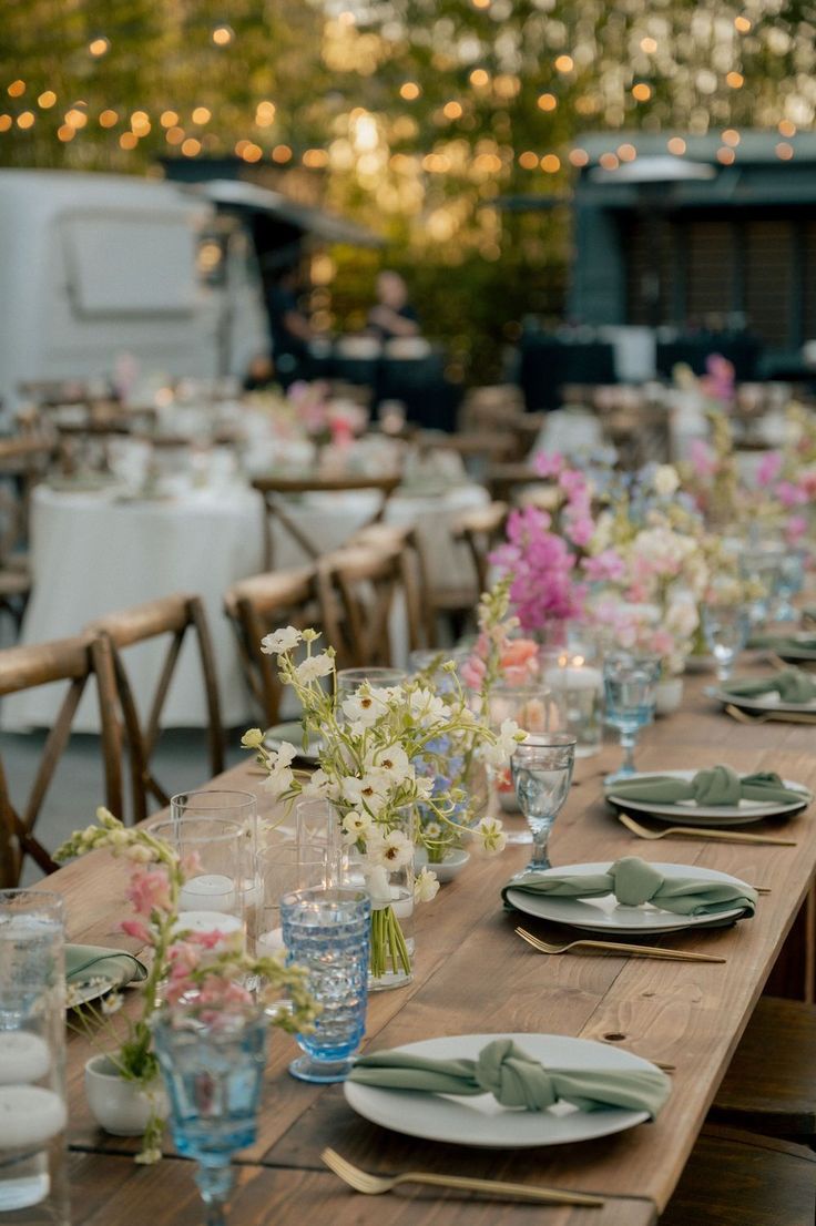 Romantic Outdoor Spring Wedding Long Table Outdoor Wedding, Outdoor Wedding Colorful, Colorful Thrifted Wedding, Minimalist Garden Wedding Reception, Summer Outdoor Wedding Ceremony, Wedding Reception Garden Party, Simple Garden Wedding Ideas Decor, Fairy Lights Garden Wedding, Wildflower Table Setting Round