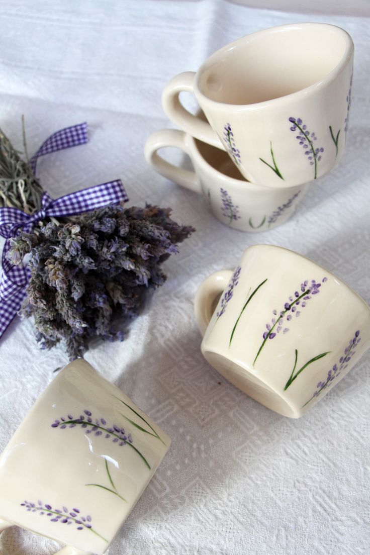 lavender tea cups and spoons on a white tablecloth