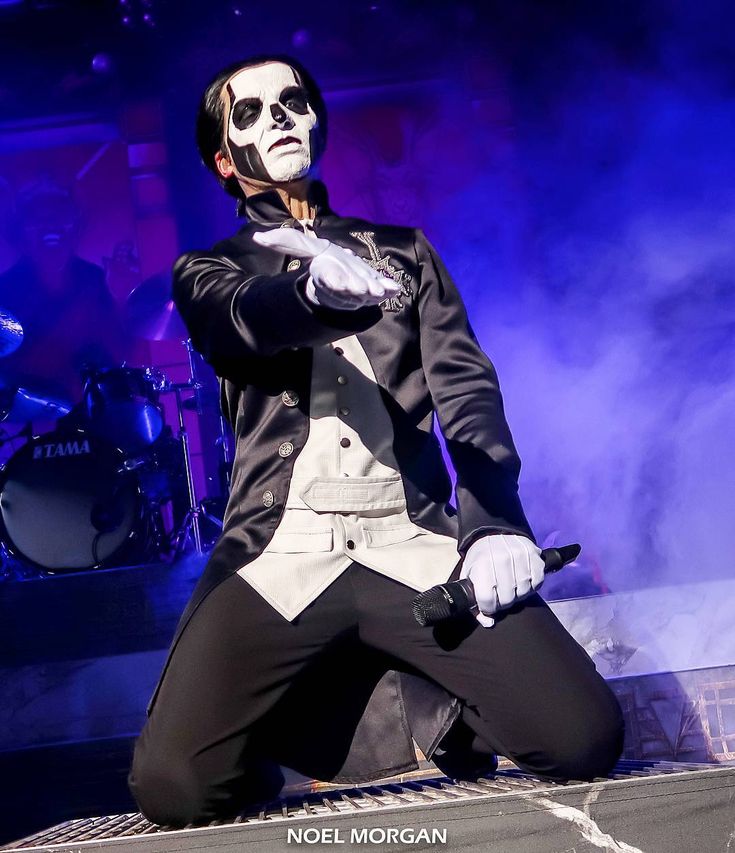 a man dressed in white and black on stage