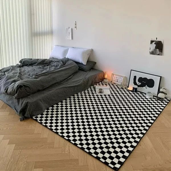 a bed sitting on top of a wooden floor next to a black and white checkered rug