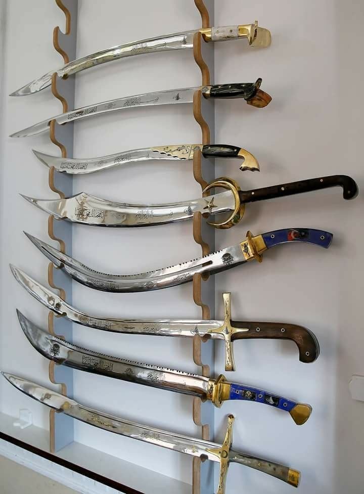 there are many different types of knives hanging on the wall in front of each other