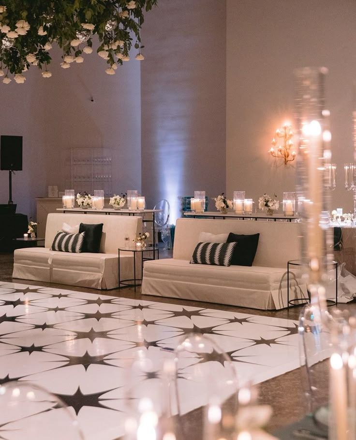 a living room filled with white couches and candles