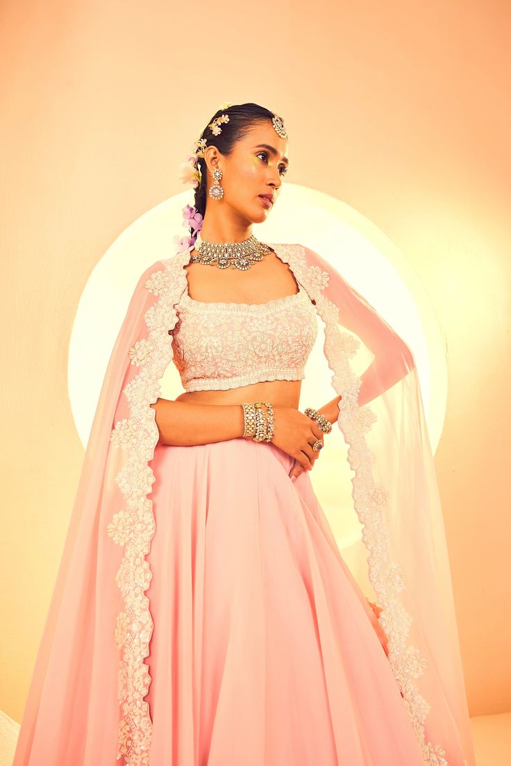 Showcasing a salmon pink cape set. It is full hand embroidered with cutdana bead and sequins embroidary. From Aneesh Agarwaal's Naksh collection. DELIVERY TIMEPlease allow 8-12 weeks for your outfit to arrive. FABRIC DETAILSOrganza Professional cleaning only. Designer Embroidered Traditional Wear With Cape Sleeves, Designer Traditional Wear With Embroidered Cape Sleeves, Embroidered Blouse Piece With Cape Sleeves For Wedding, Traditional Embroidered Anarkali Set With Cape Sleeves, Pink Embroidered Palazzo Set For Reception, Traditional Palazzo Set With Cape Sleeves In Georgette, Traditional Sharara With Dabka Work And Cape Sleeves, Festive Embellished Lehenga With Cape Sleeves, Embellished Lehenga With Cape Sleeves For Festivals