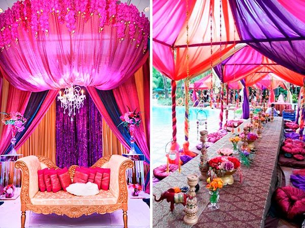 an outdoor wedding venue decorated with pink and purple draping, white couches, and chandeliers