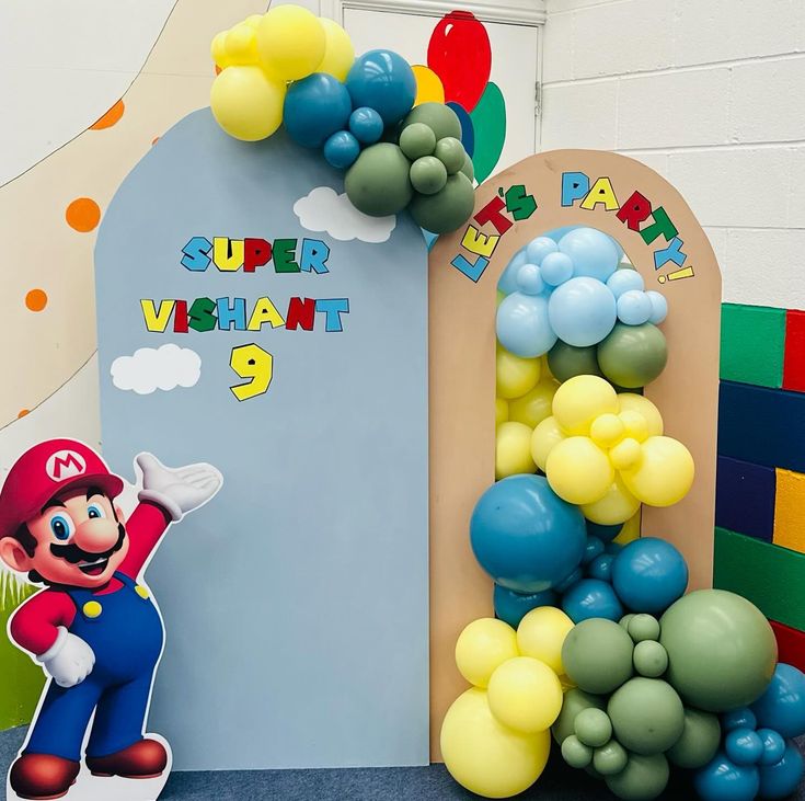 a super mario birthday party with balloons and balloon arch for the entrance to the room