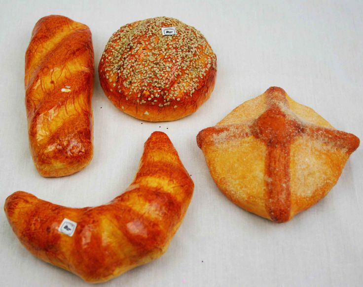 breads and pastries are arranged on a white surface