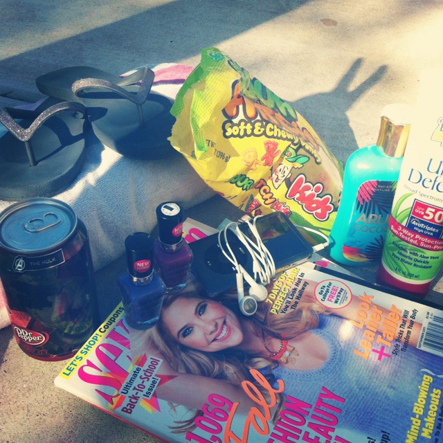 the contents of a woman's purse sitting on the ground next to other items