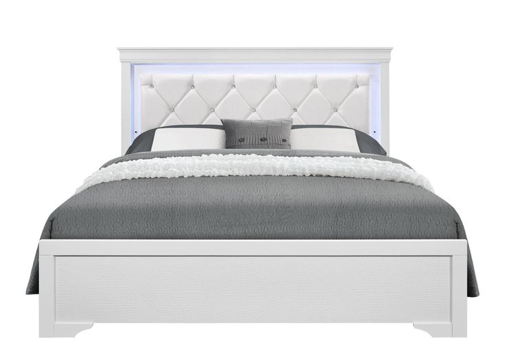 a white bed with an upholstered headboard and foot board