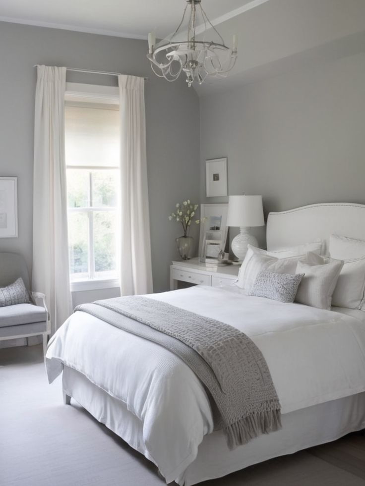 a white bed sitting in a bedroom next to a window