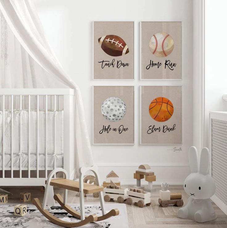 a baby's room with sports themed artwork on the wall