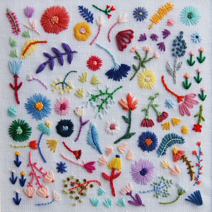 a cross stitch pattern with various flowers and plants on white fabric, all in different colors