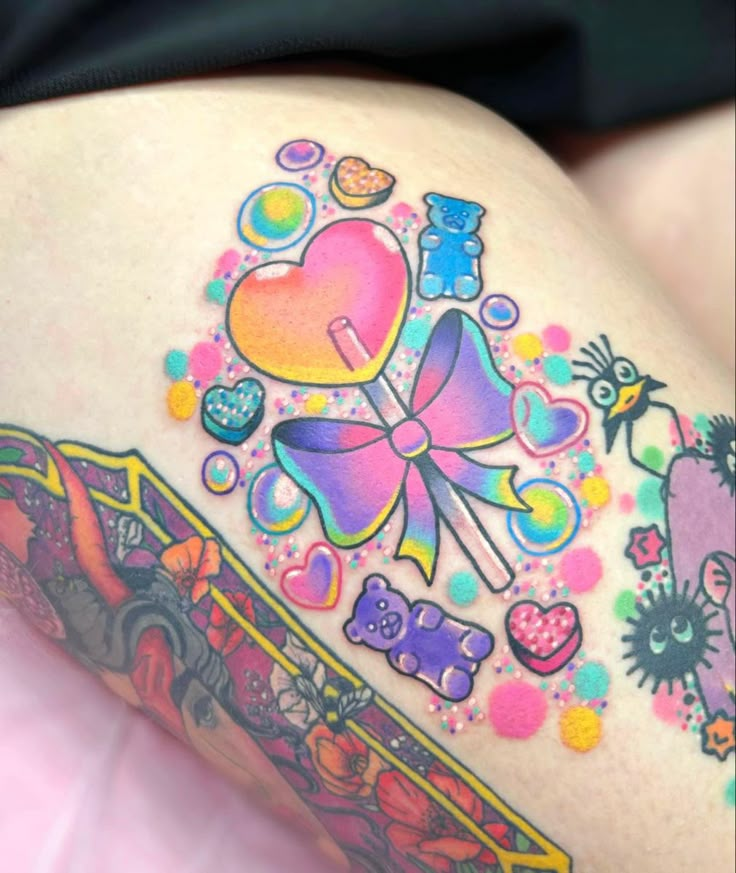 colorful tattoos on the thigh of a woman's legs and thighs are decorated with candies