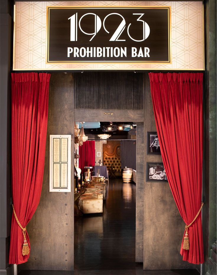 an entrance to a bar with red curtains