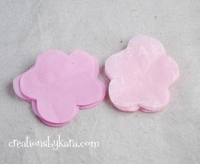 two pink flower shaped coasters sitting next to each other