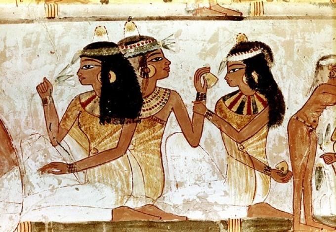 ancient egyptian paintings depicting two women and one is holding an object in her hand while another woman looks on