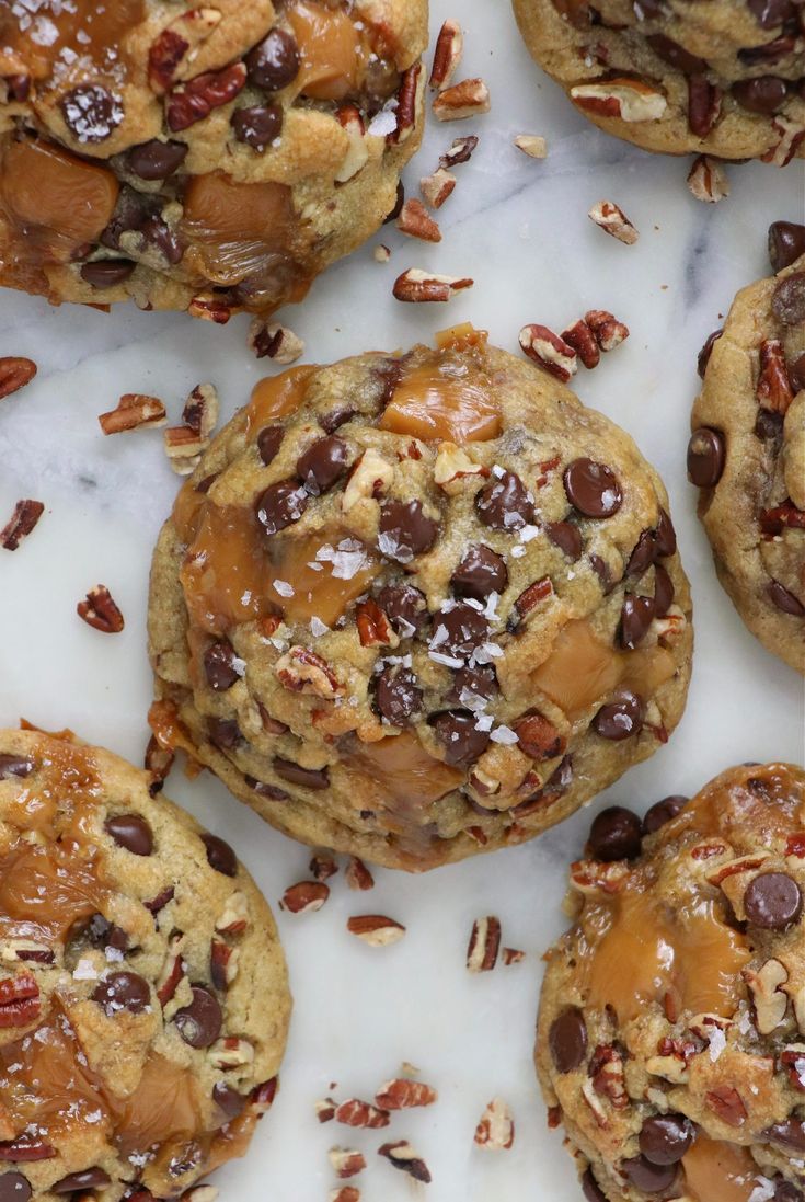 chocolate chip cookies with pecans and nuts on a marble counter top, ready to be eaten