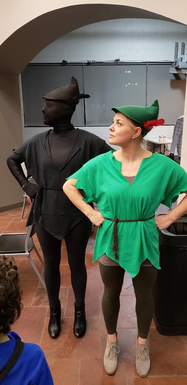 two women standing in front of three black mannequins, one wearing a green top