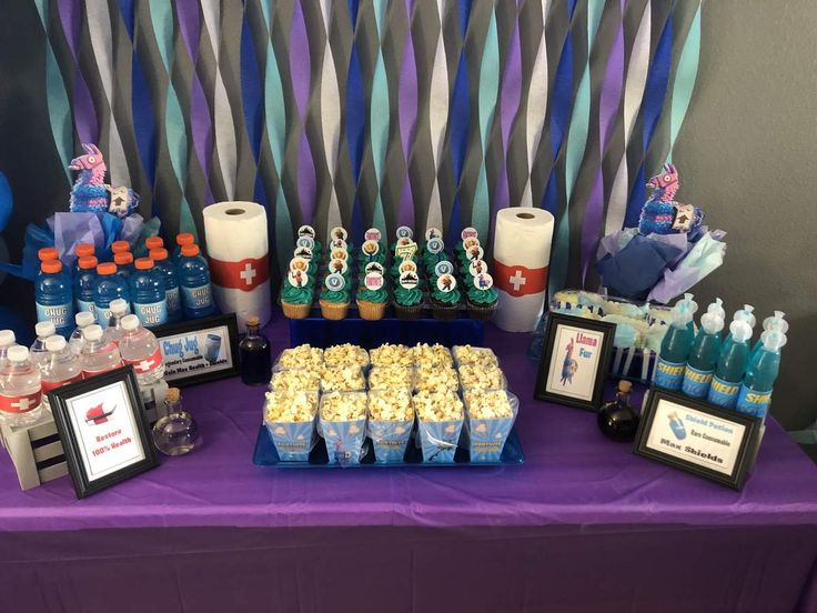 a purple table topped with lots of food and drinks