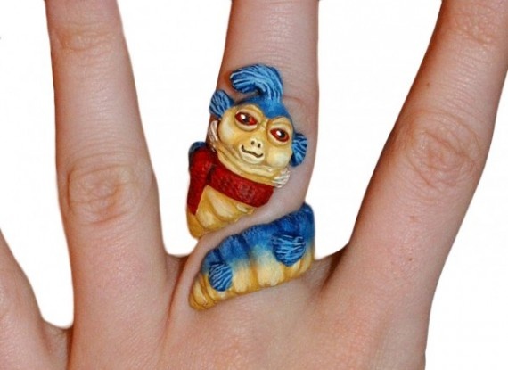 a person's hand with a ring made to look like a small monkey on it