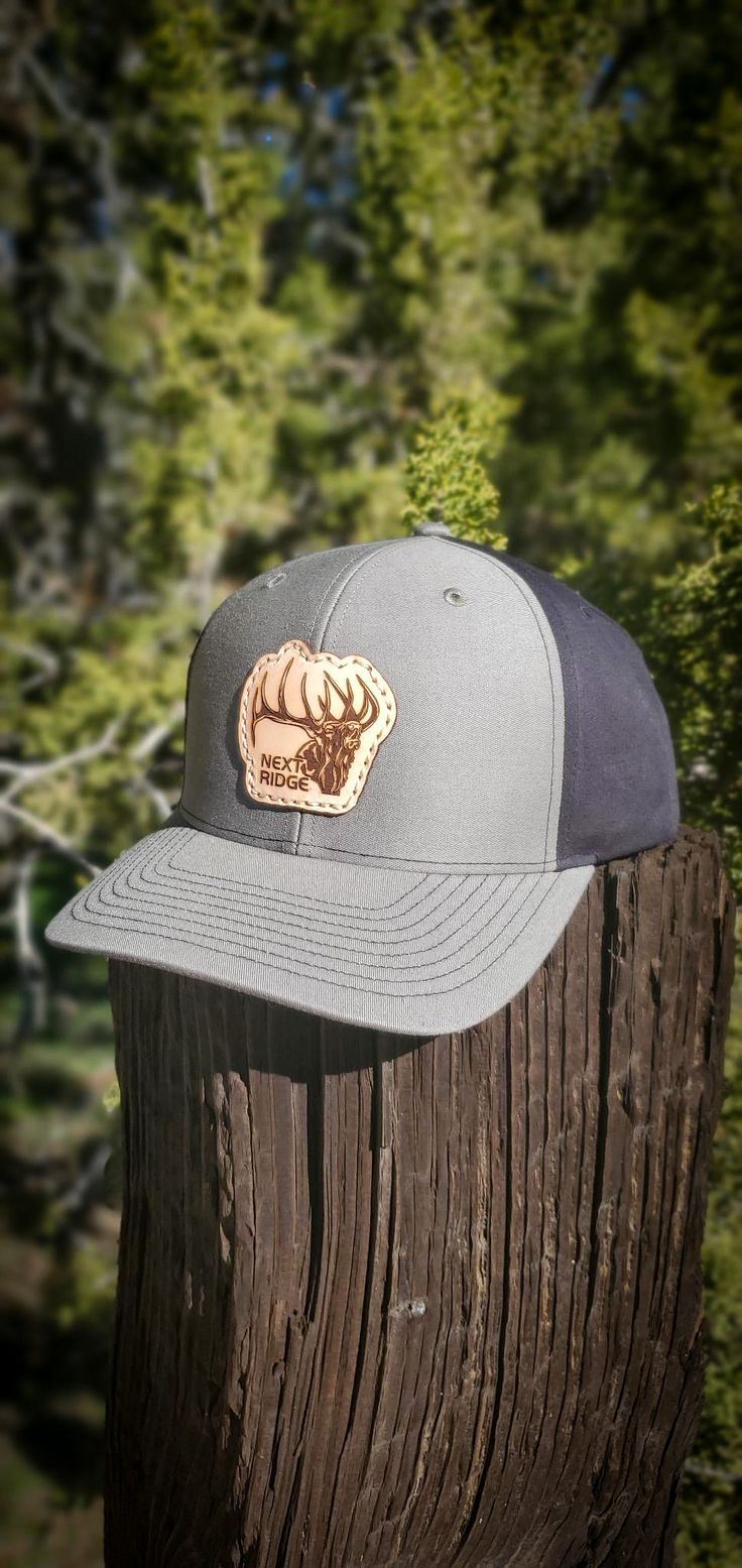 Introducing the Screamin Bull Elk Leather Patch Hat from Next Ridge Apparel, the perfect accessory for the outdoors enthusiast in your life. This premium hat is crafted from durable, high-quality materials and features a stylish leather patch featuring a screaming bull elk design. The hat is designed for casual, everyday wear, making it a versatile addition to your wardrobe. Whether you're out hunting, fishing, hiking, or camping, this hat will keep you comfortable and protected from the element Western Style Snapback Hat For Outdoor, Western Style Baseball Cap With Flat Bill For Outdoor, Western Hats With Leather Patch For Outdoor, Western Snapback Hat With Flat Brim For Outdoors, Western Style Snapback Hat With Curved Brim For Outdoor, Western Style Baseball Cap With Curved Brim For Outdoor, Western Outdoor Hat With Leather Patch, Western Style Snapback Hat With Curved Brim, Western Style Snapback Hat With Flat Brim For Outdoor