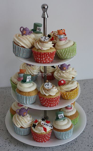 three tiered cupcake display with various types of cupcakes on each tier