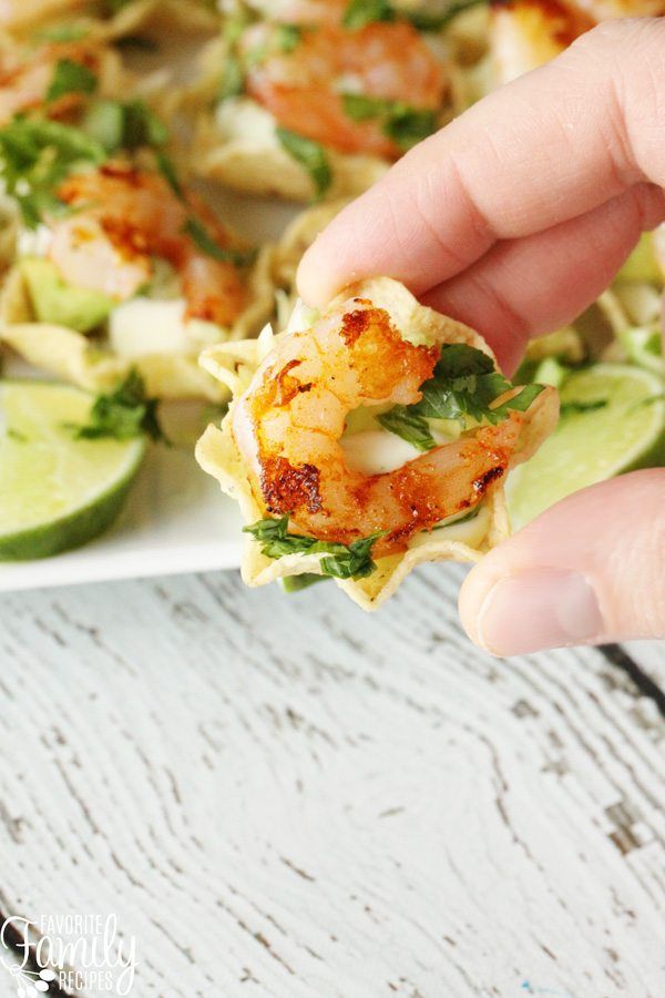 someone is holding up some food on a plate with avocado and shrimp in it