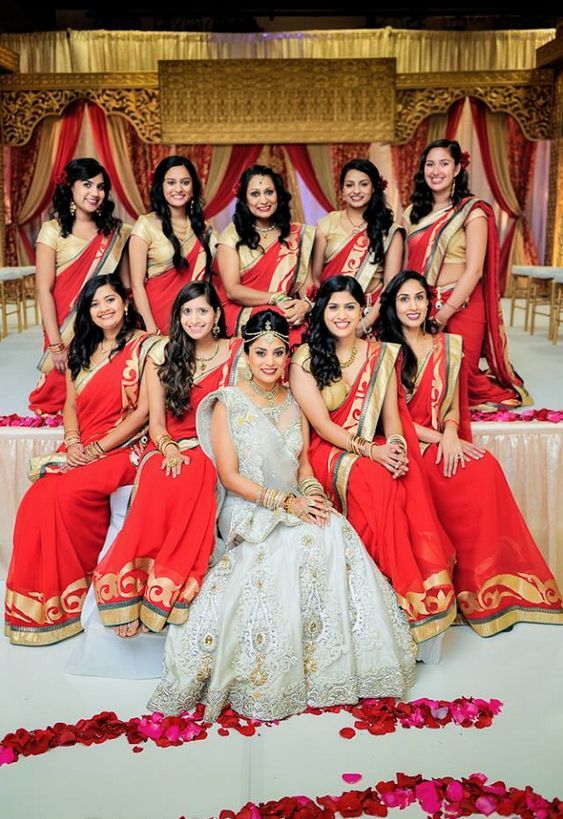 a group of women in red and gold dresses posing for a photo with each other