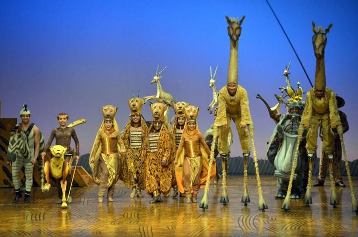 a group of people dressed in costumes on stage