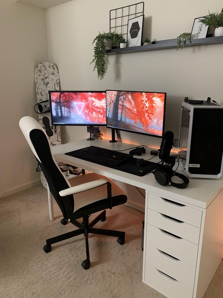 two computer monitors sitting on top of a white desk