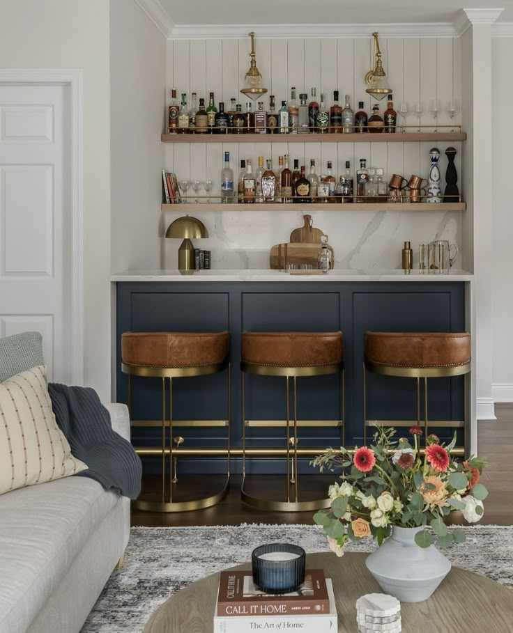 a living room filled with furniture and lots of bottles on top of the shelves next to a bar