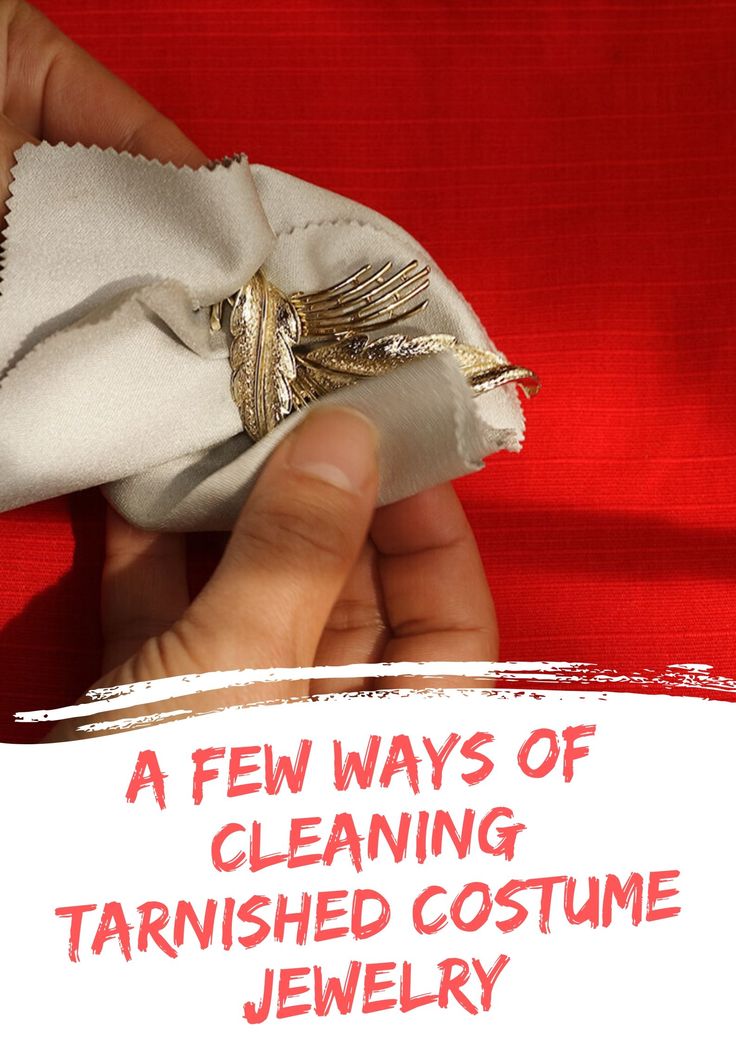 a person is holding a white cloth with gold accents on it and the words, a few ways of cleaning tarnished costume jewelry