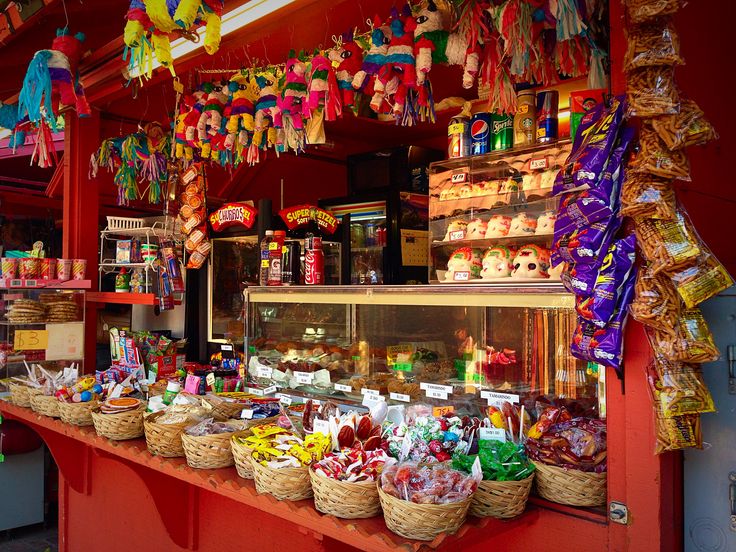 the candy stand has many different types of candies in baskets and on top of it