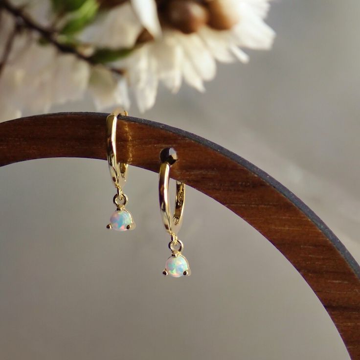 These chic and versatile opal huggie hoop earrings are available in either sterling silver or sterling silver electroplated in 14k gold. The little opals are ethical, lab-created gemstones and offer a timeless and classic look. SOLD AS A PAIR✨ Features:Premium Materials: Crafted from high-quality Sterling Silver and/or plated with 14k gold, these hoops offer a beautiful shine and exceptional durability.Hypoallergenic: Nickel-free and hypoallergenic, these earrings are gentle on sensitive skin, e Small Hoop Opal Earrings For Gift, Hypoallergenic Opal Drop Earrings, Minimalist Huggie Birthstone Earrings, Minimalist Birthstone Huggie Earrings, Dainty Hypoallergenic Opal Earrings, Hypoallergenic Opal Dangle Jewelry, Opal Huggie Earrings Gift, Elegant Opal Huggie Jewelry, Elegant Opal Huggie Earrings