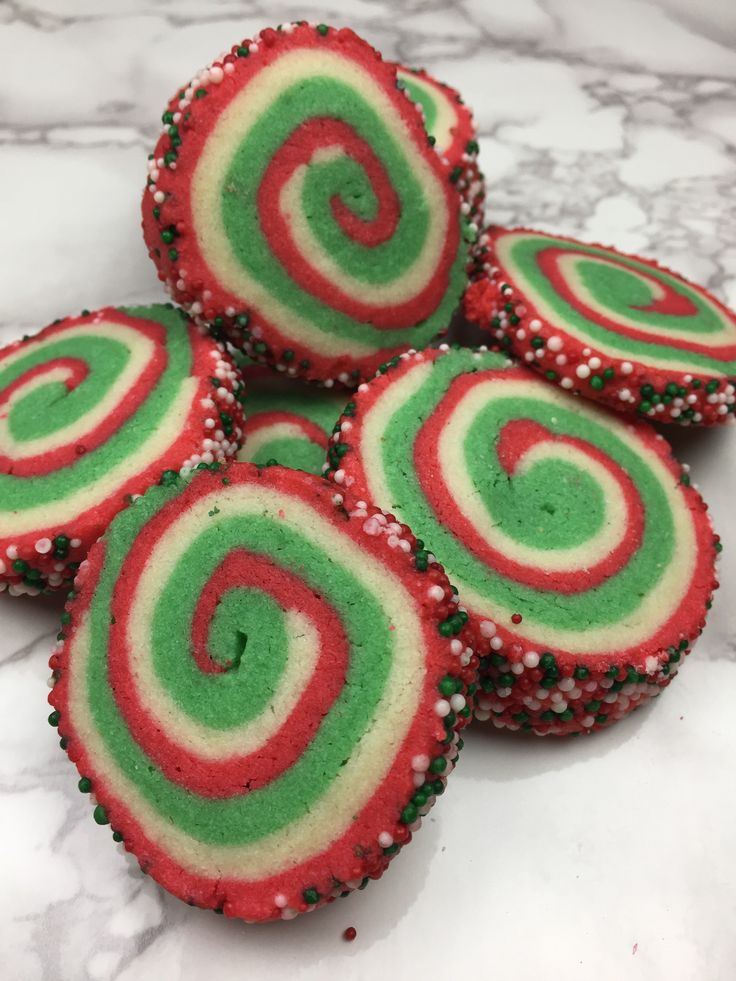 four red, green and white cupcakes with sprinkles on top