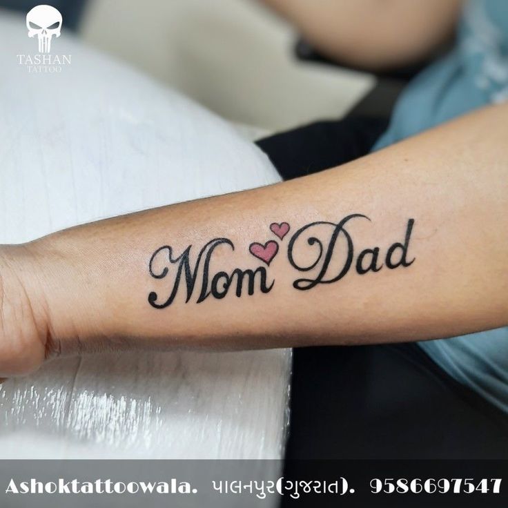 a woman's arm with a tattoo that says mom dad on it and a heart in the middle