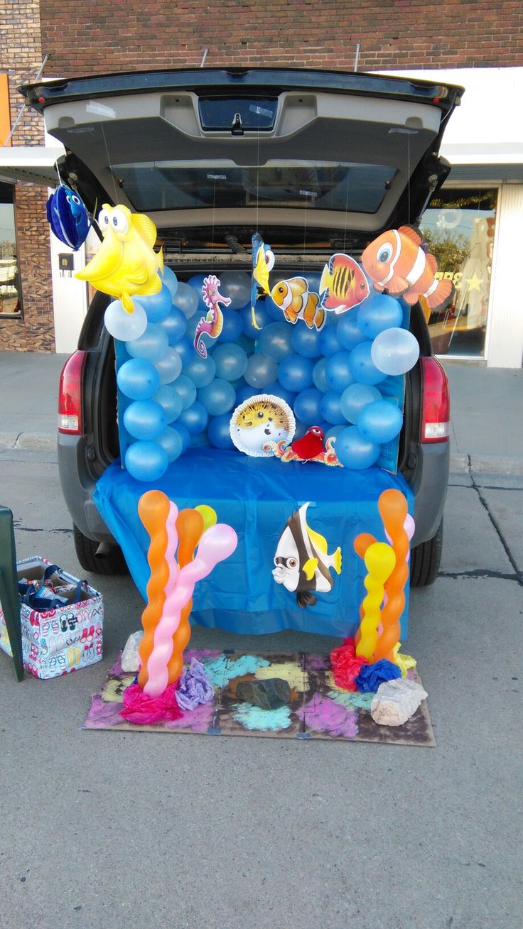 the trunk of a car is filled with balloons and decorations for an underseam birthday party