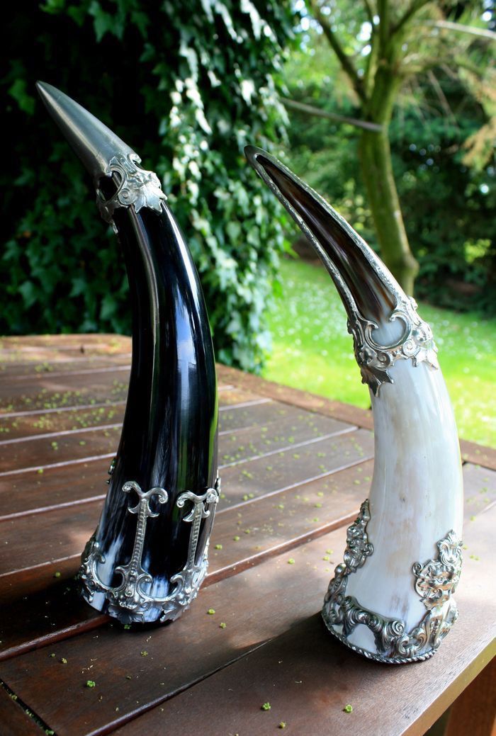 two black and white vases sitting on top of a wooden table