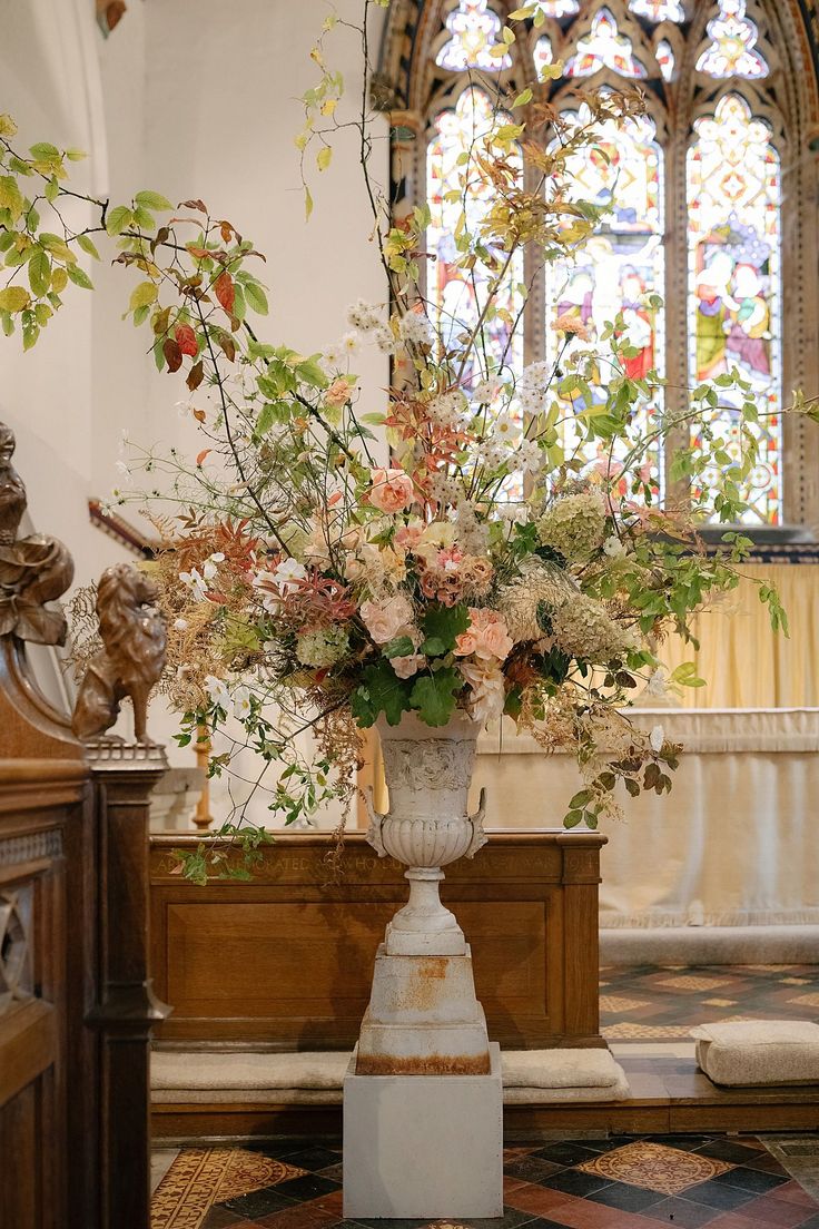 a vase filled with lots of flowers on top of a table next to a window