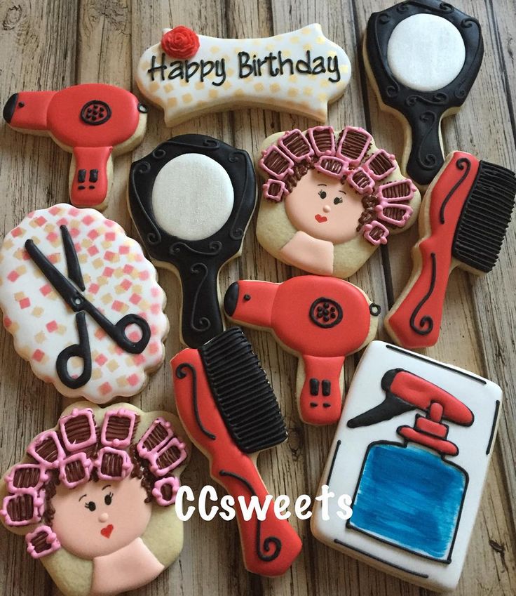 decorated cookies are arranged in the shape of hairdryers, scissors and combs