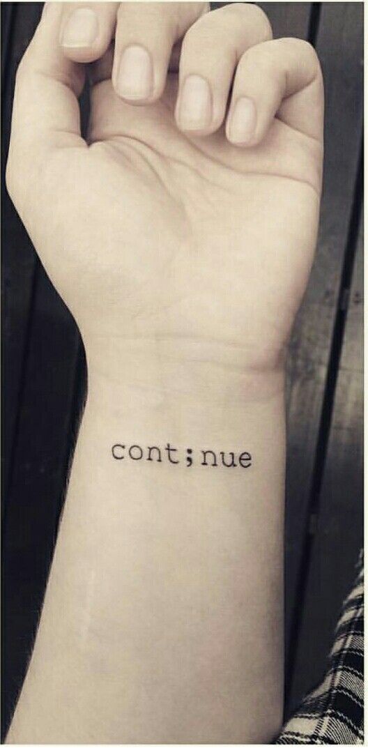 someone is holding their arm up with the word continue tattooed on it's wrist