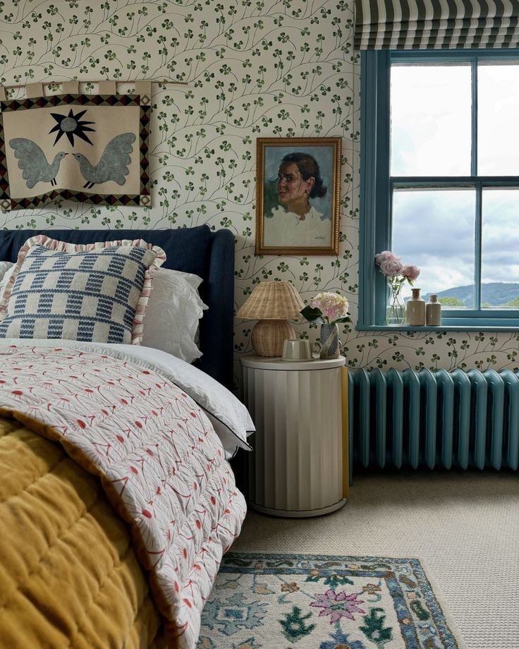 a bedroom with floral wallpaper and blue bedding